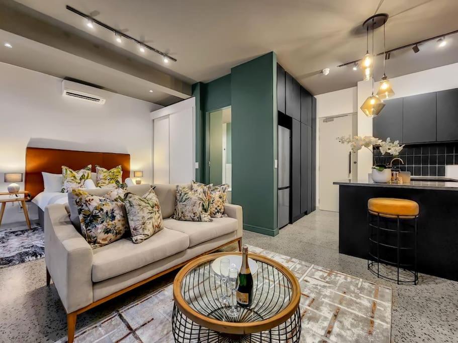 a living room with a couch and a table at Upmarket and Stylish Apartment With Rooftop Pool. in Cape Town