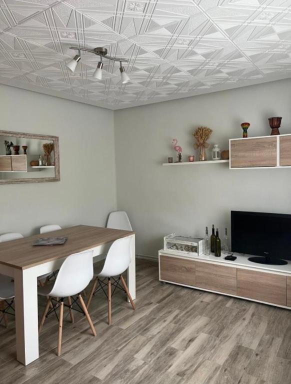 a dining room with a table and chairs and a tv at Piso Los Jardines in Peñaranda de Bracamonte