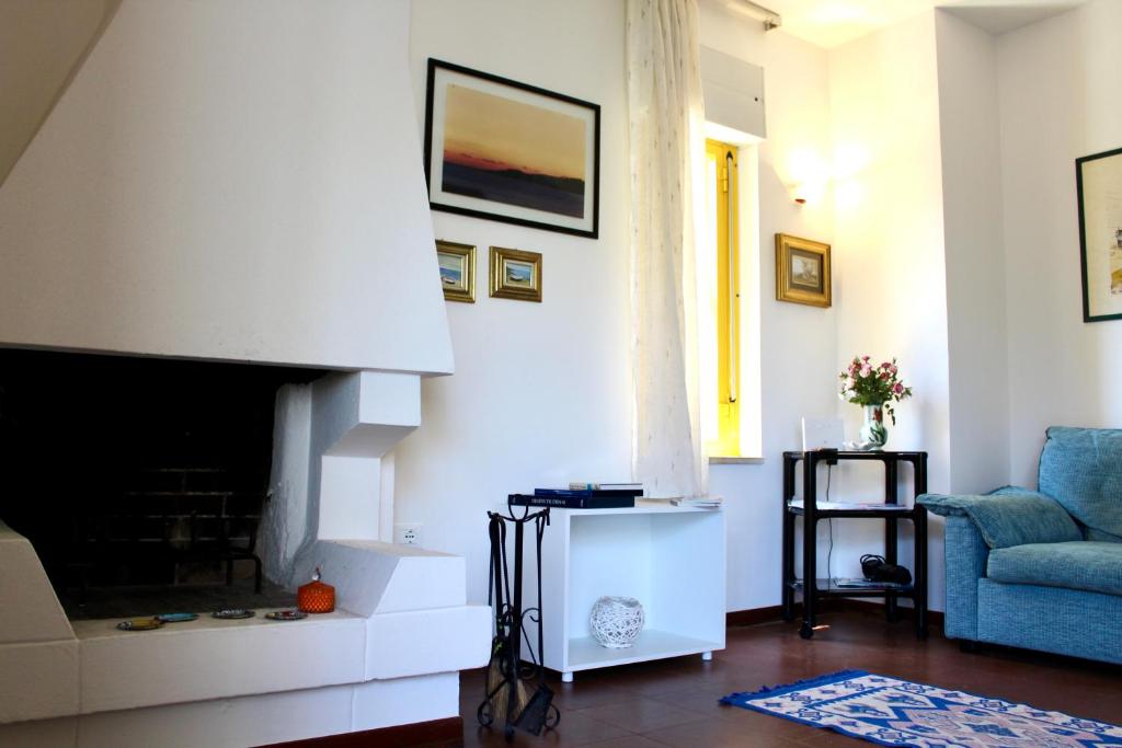 a living room with a fireplace and a blue chair at Dimora dei pini in Leuca