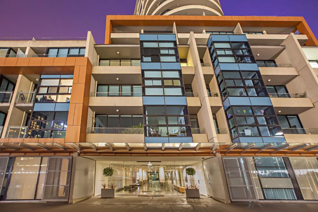 una vista exterior de un edificio con ventanas azules en Melbourne Holiday Apartments Flinders Wharf, en Melbourne