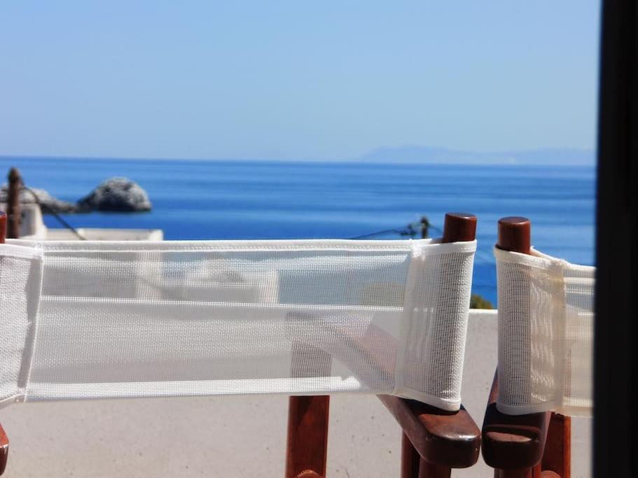 - une table et des chaises en plastique avec vue sur l'océan dans l'établissement Ageri Home, à Karavostasi