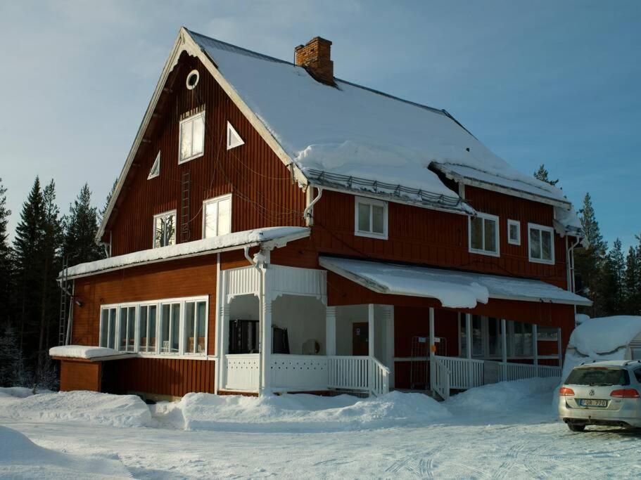 a house covered in snow with a car parked in front at Hedsjövägen 23 med 350m sandstrand 