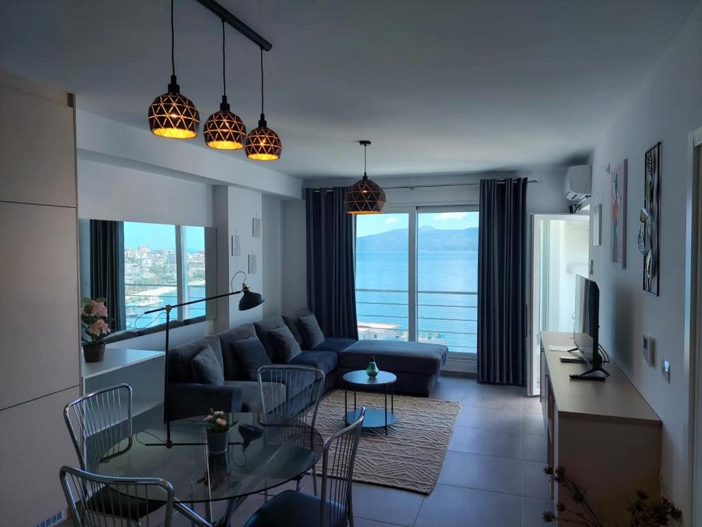 een woonkamer met een bank en een tafel bij Mihaly Apartment in Sarandë