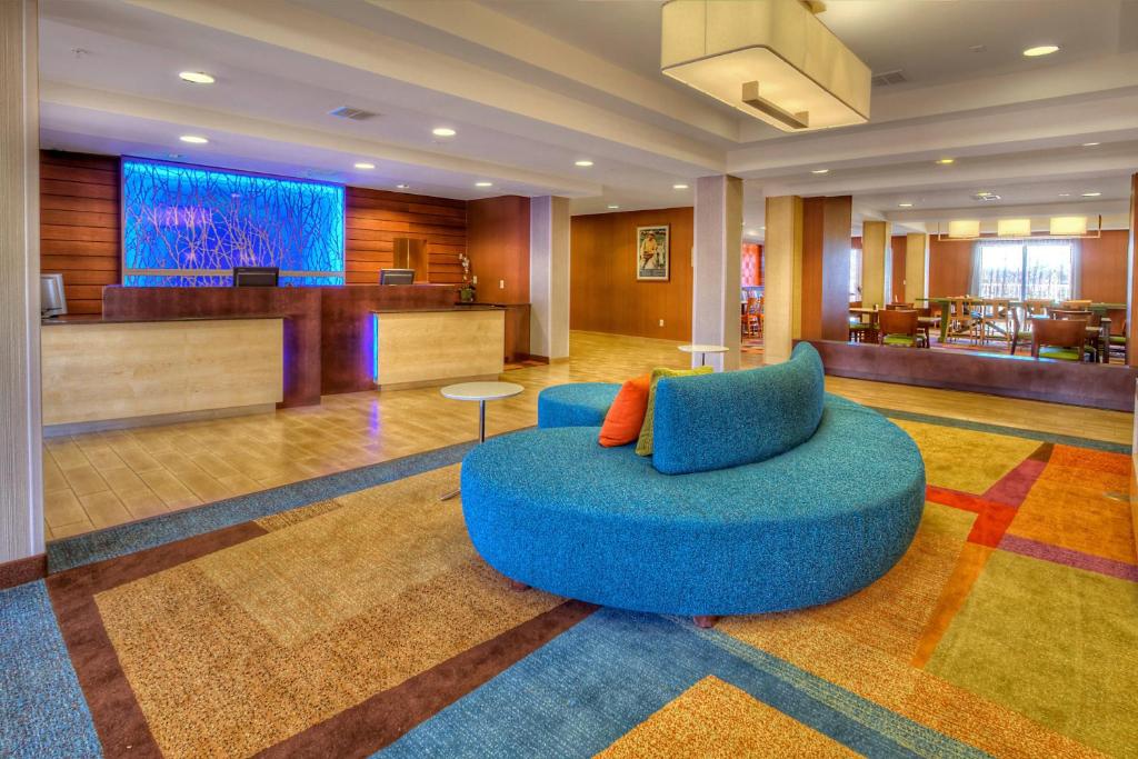 a large lobby with a blue chair in the middle at Fairfield Inn & Suites by Marriott Edmond in Edmond