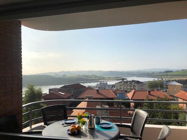een tafel en stoelen op een balkon met uitzicht bij Vistas Sol y Mar in Suances