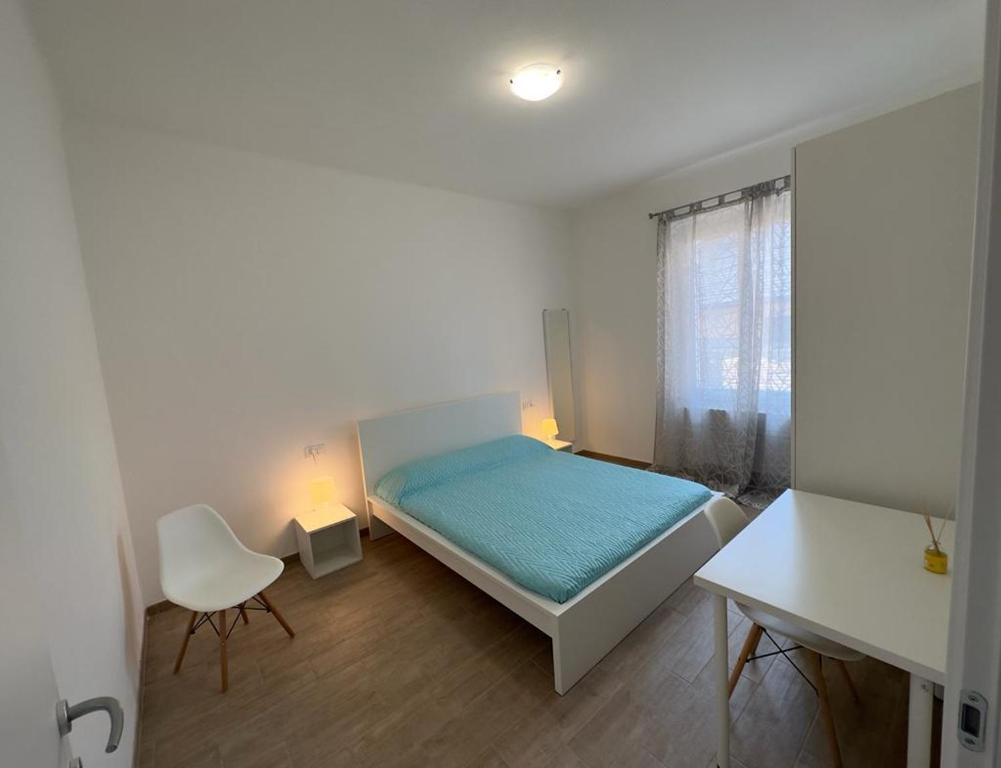 um quarto com uma cama, uma cadeira e uma janela em Ambrogio Mare em Varazze