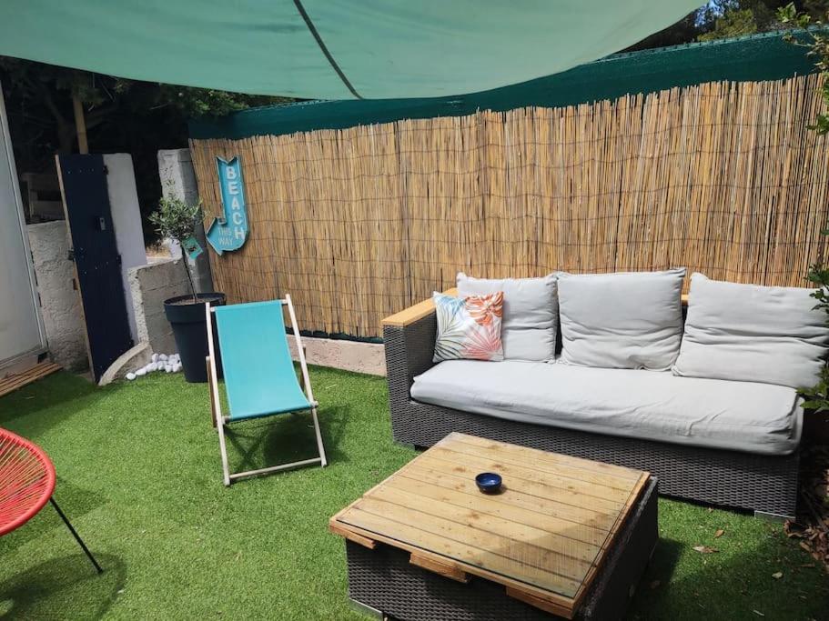 een bank en een tafel in de tuin bij Bord de mer : studio avec salon d'été à Sausset in Sausset-les-Pins