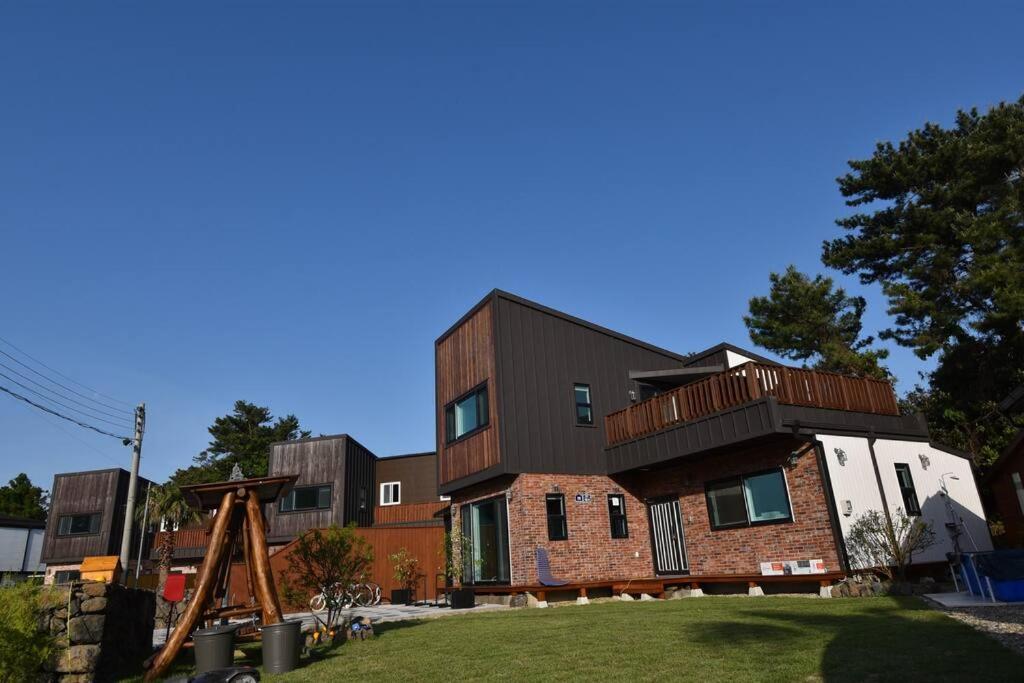 un edificio in mattoni con balcone sopra di Jo and Lee Kids House a Seogwipo