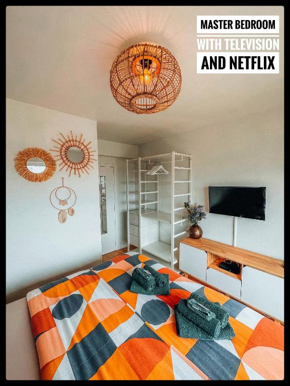 a bedroom with a colorful bed with a television and netflix at CASA MARE hartje Oostende met gratis parking in Ostend