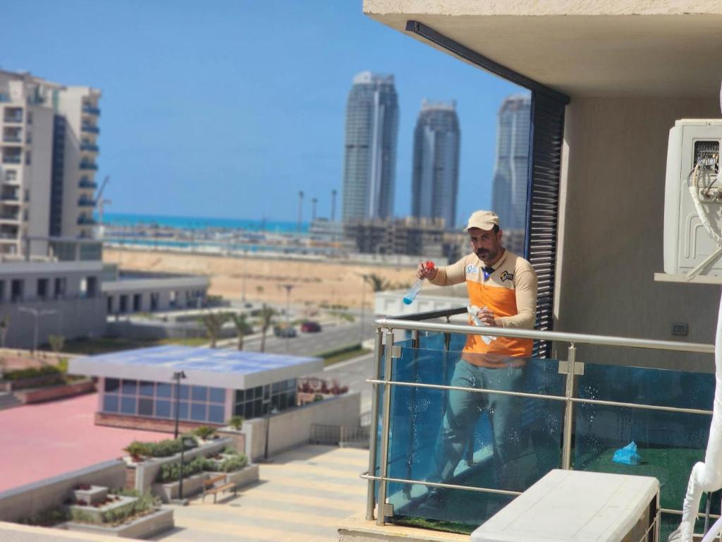 a man standing on the balcony of a building at الداون تاون العلمين الجديده خلف الابراج El Down Town New El Alamaein in El Alamein