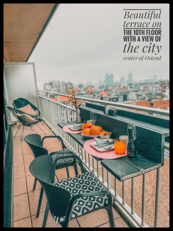 a table on a balcony with a view of the city at CASA MARE hartje Oostende met gratis parking in Ostend