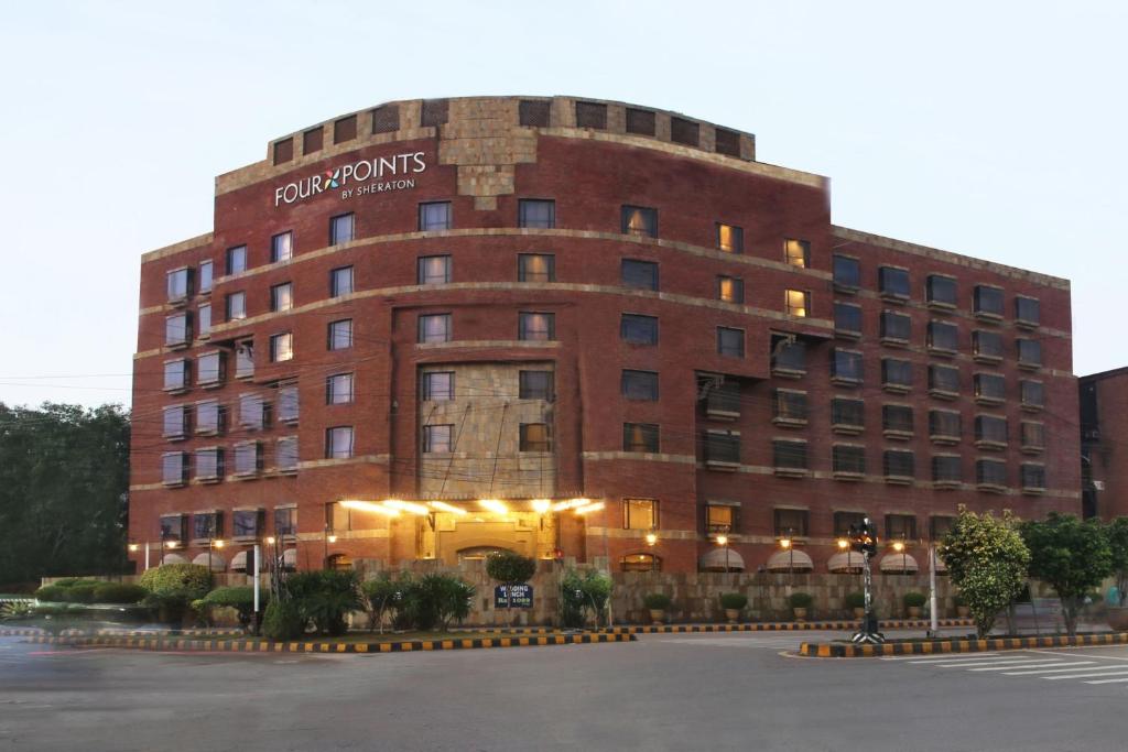 un gran edificio de ladrillo rojo con un cartel. en Four Points by Sheraton Lahore, en Lahore