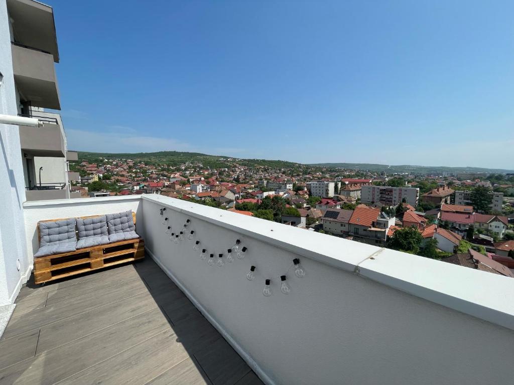 a balcony with a bench and a view of a city at East View by DAT Apartments in Cluj-Napoca