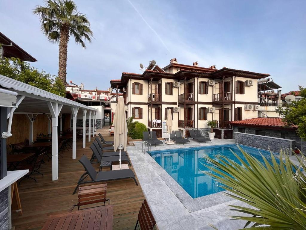 a house with a swimming pool in front of a house at Yelken Hotel Akyaka in Akyaka