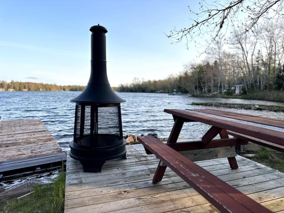 una lanterna seduta su un molo accanto a una panchina di Archie's Lakeside Cabin a Wolfville