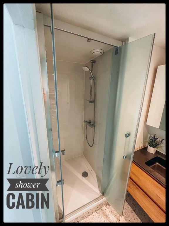 a shower stall with a glass door in a bathroom at CASA MARE hartje Oostende met gratis parking in Ostend