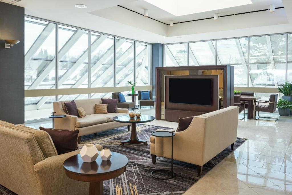 a living room with couches and a flat screen tv at Sheraton Detroit Novi in Novi