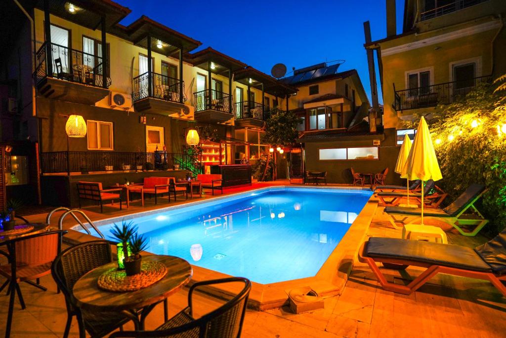 a swimming pool with tables and chairs next to a building at Four Seasons Apart Hotel in Dalyan