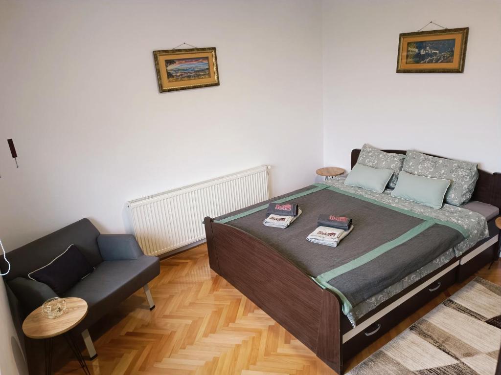 a bedroom with a bed and a couch at Apartman HeLena in Soko Banja