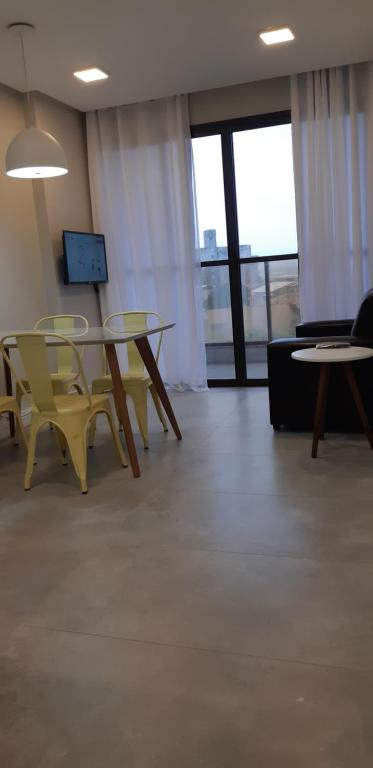 een kamer met een tafel en stoelen en een bank bij Ap 305 Praia Castelhanos in Anchieta