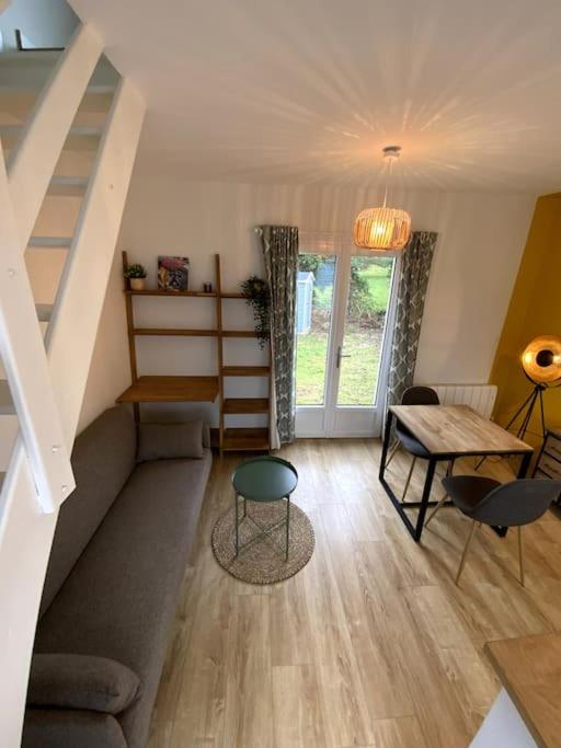 ein Wohnzimmer mit einem Sofa und einem Tisch in der Unterkunft Charmante petite maison in Les Renardières
