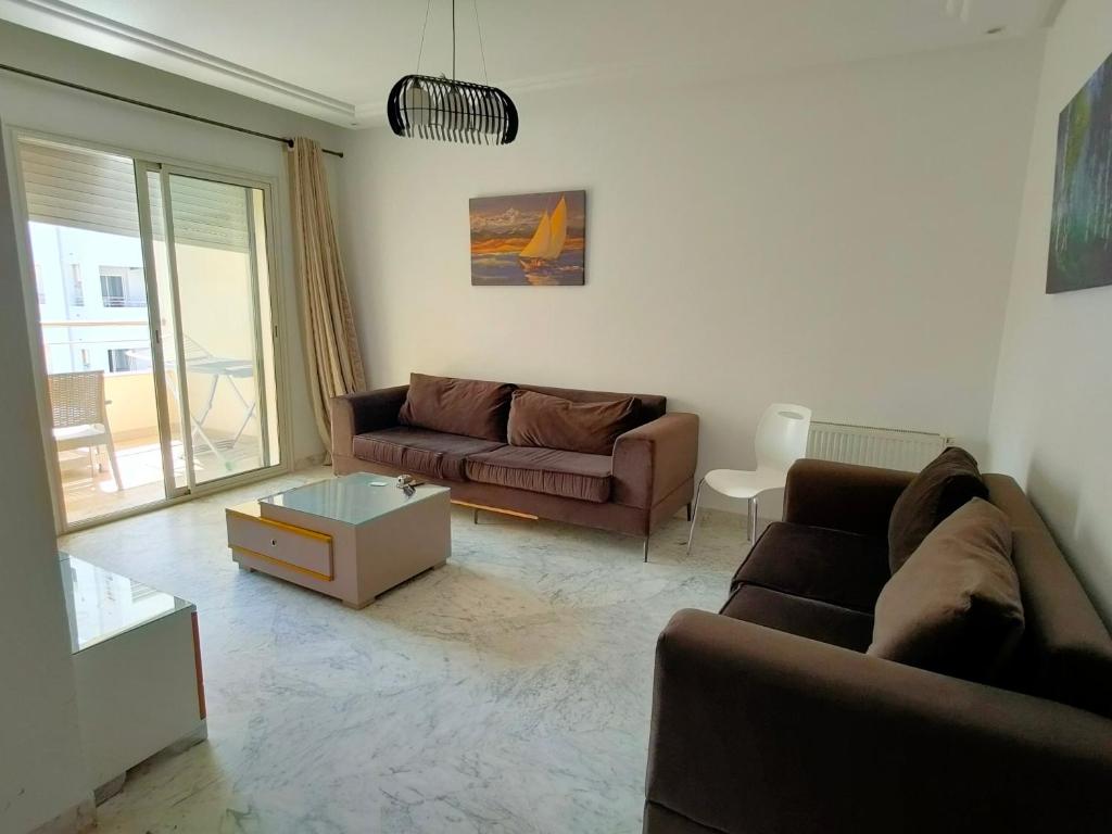 uma sala de estar com um sofá e uma mesa em luxe & VIP appartement a côté de tunsia mall lac 2 em Tunes