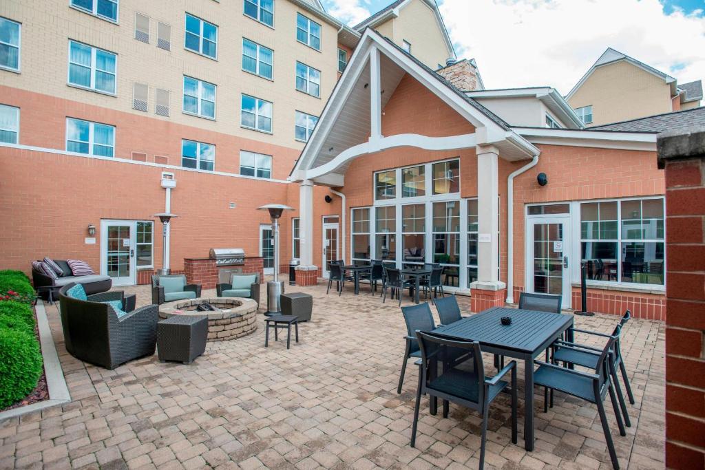 un patio con mesas y sillas frente a un edificio en Residence Inn Cincinnati North West Chester, en West Chester