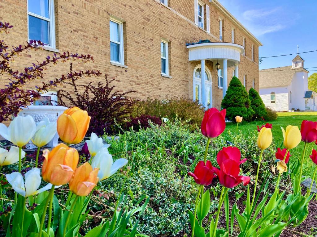 a garden of flowers in front of a house at Garden Grove Retreat & Lodging near Pictured Rocks, Fayette, Trails in Garden