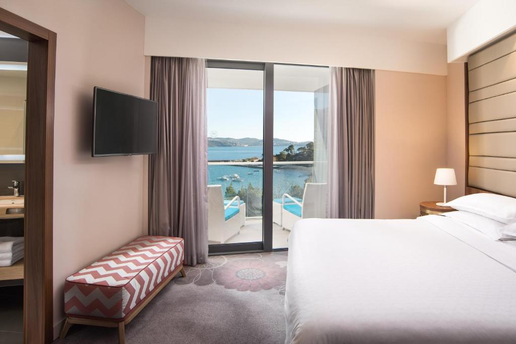 a hotel room with a bed and a view of the water at Sheraton Dubrovnik Riviera Hotel in Mlini