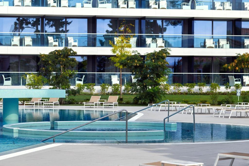 uma piscina em frente a um edifício em Sheraton Dubrovnik Riviera Hotel em Mlini