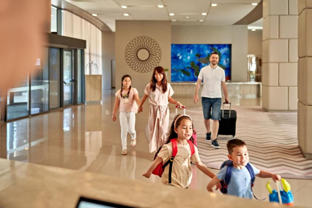 a family walking through an airport with their luggage at Sheraton Dubrovnik Riviera Hotel in Mlini