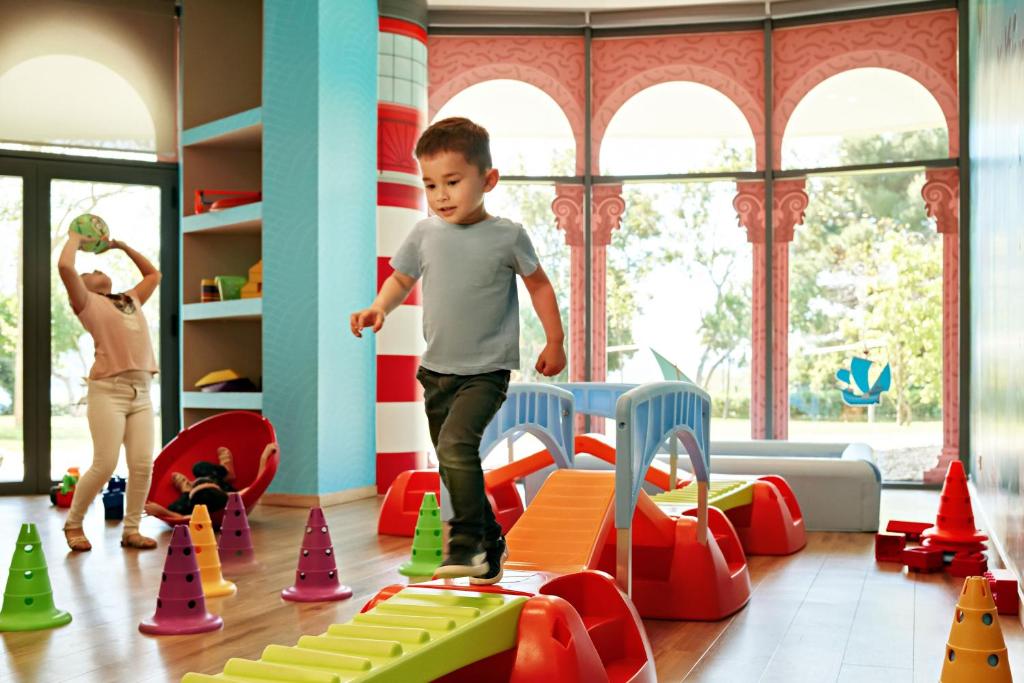 a young boy playing on a toy track in a play room at Sheraton Dubrovnik Riviera Hotel in Mlini