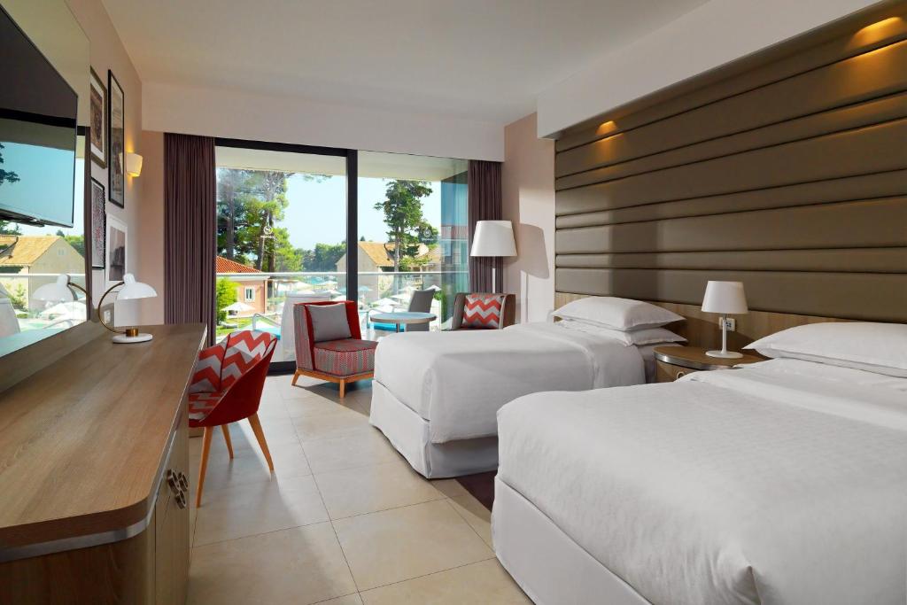 a hotel room with two beds and a desk at Sheraton Dubrovnik Riviera Hotel in Mlini