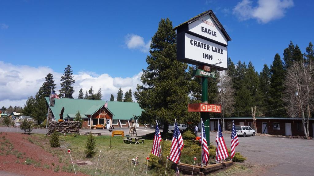un cartello per una stazione di servizio con bandiere americane di Eagle Crater Lake Inn a Chemult