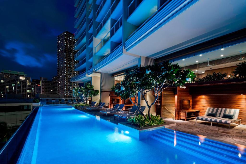 a pool on the roof of a building at night at The Ritz-Carlton Residences, Waikiki Beach Hotel in Honolulu