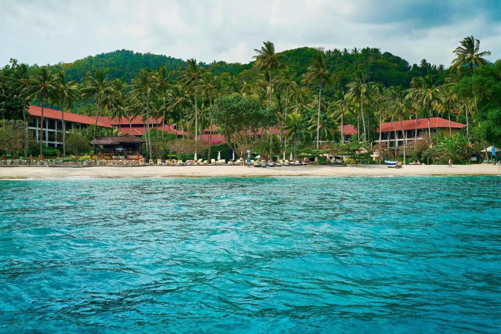 a view of a beach with palm trees and a resort at Sheraton Senggigi Beach Resort in Senggigi