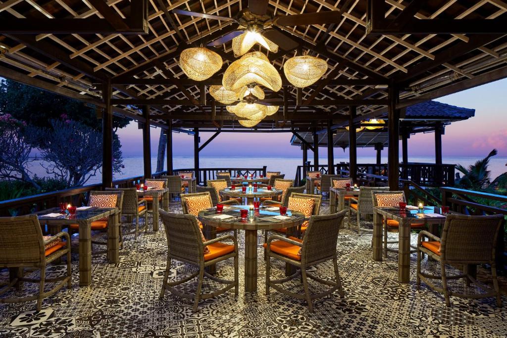 a restaurant with tables and chairs and a chandelier at Sheraton Senggigi Beach Resort in Senggigi
