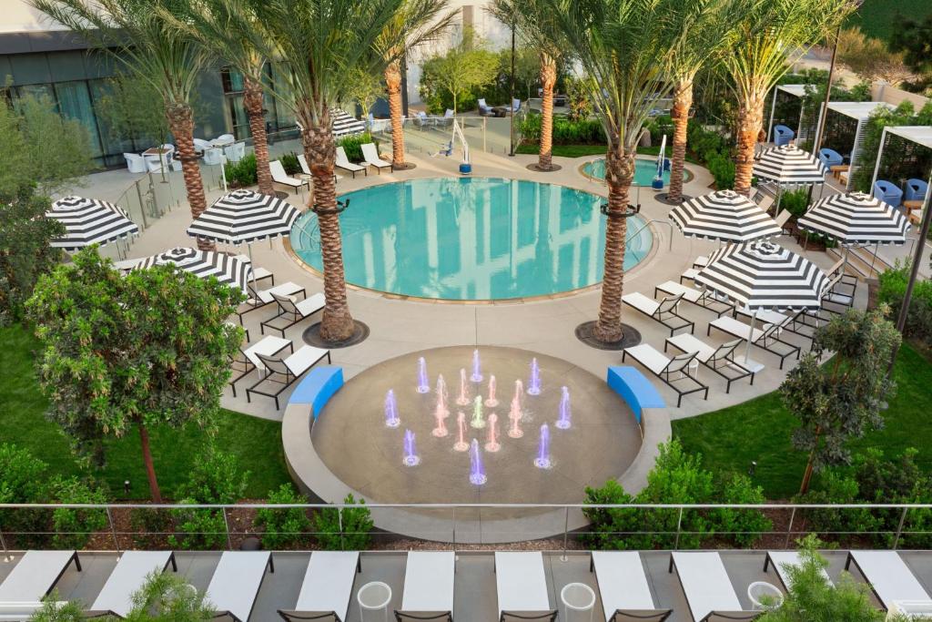 an overhead view of a pool with chairs and palm trees at The Viv Hotel, Anaheim, a Tribute Portfolio Hotel in Anaheim