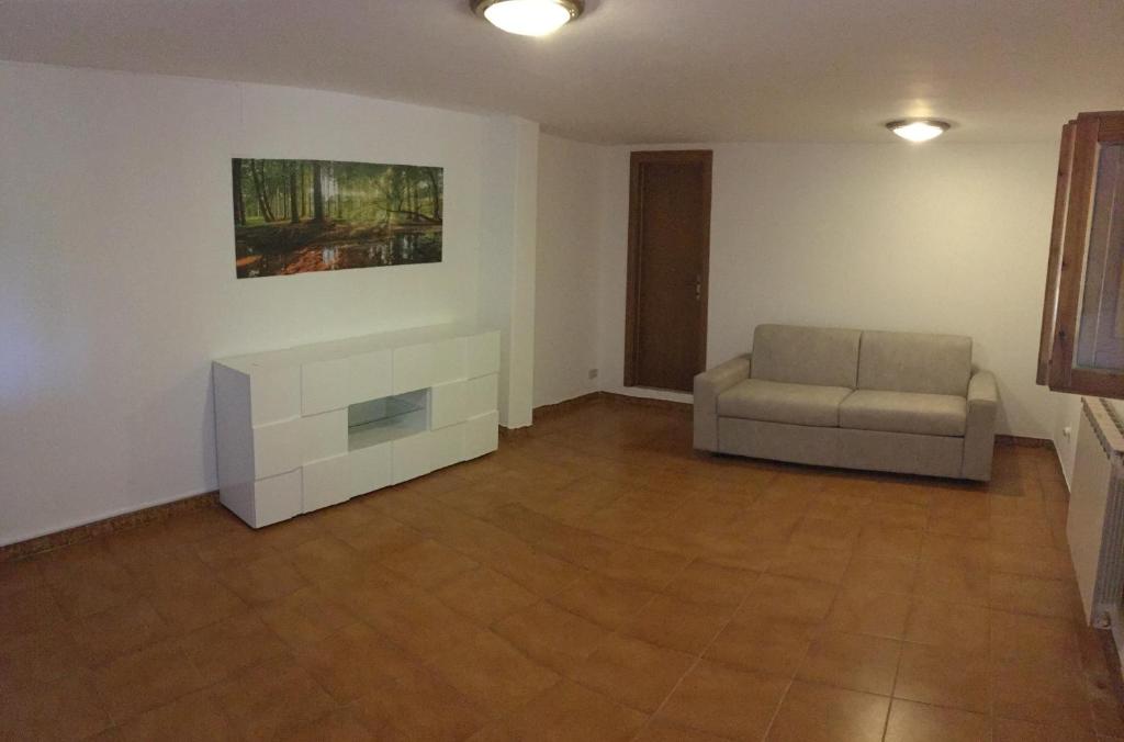 una sala de estar con sofá y una pintura en la pared en Appartamento Bellavista, en Castiglioncello