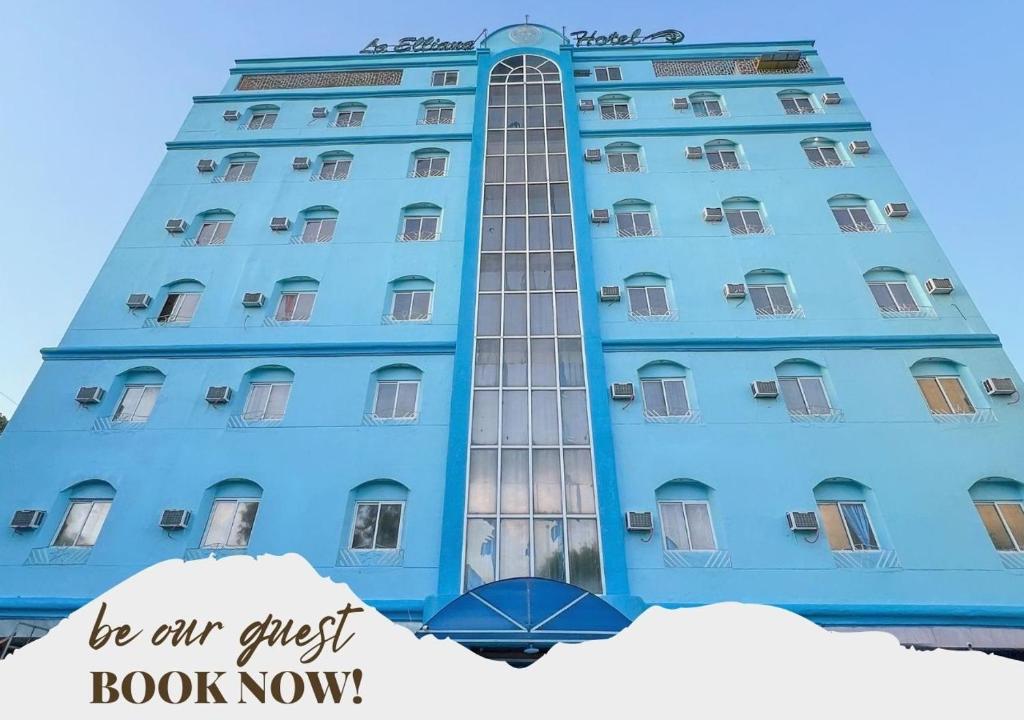 a blue building with the words be an guest book now at La Elliana Hotel & Restaurant, Inc. in Laoag