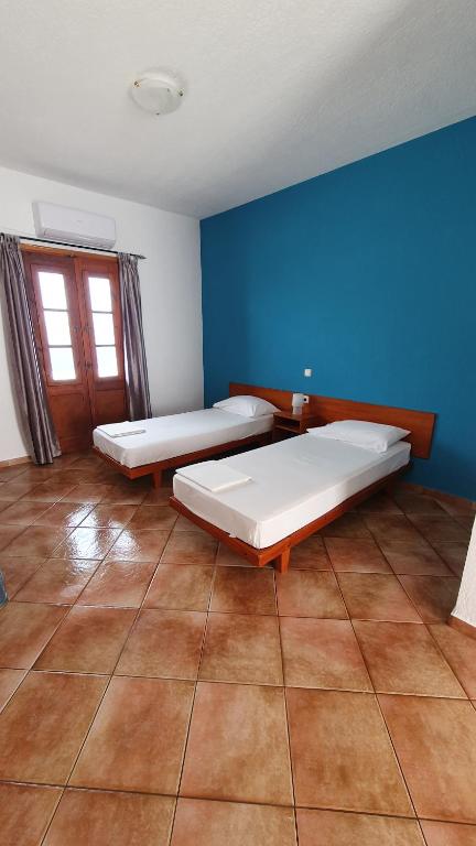 a bedroom with two beds and a blue wall at Blue Sand 2 in Masouri