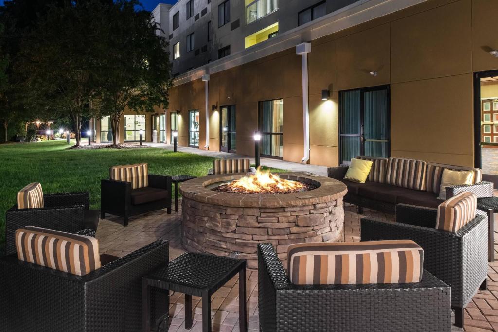 a patio with chairs and a fire pit in front of a building at Courtyard Charlotte Gastonia in Gastonia