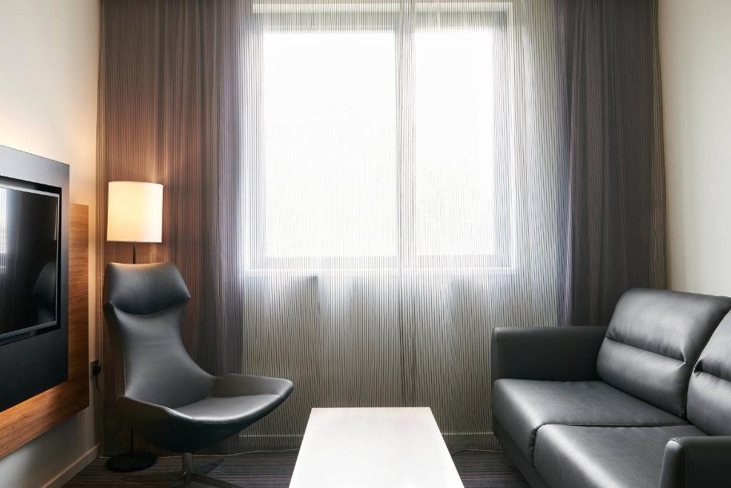 a living room with a couch and a window at Moxy Aberdeen Airport in Dyce