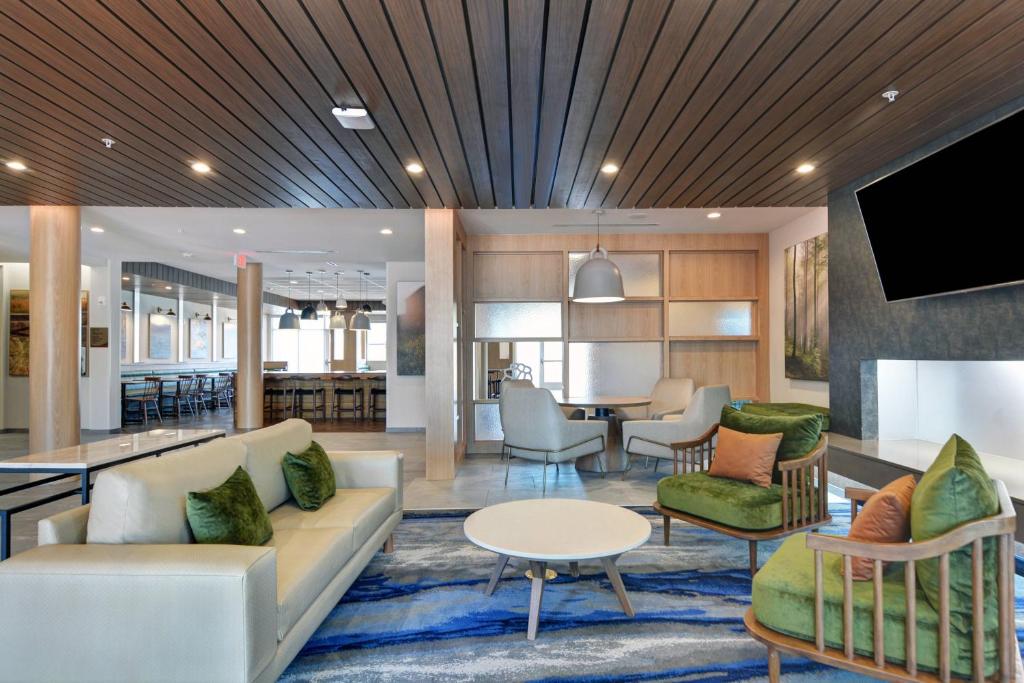 een lobby met een bank en stoelen en een tv bij Fairfield Inn & Suites by Marriott Houston NASA/Webster in Webster