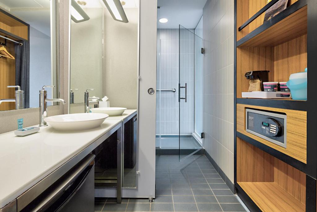 a bathroom with two sinks and a shower at Aloft Dallas Downtown in Dallas