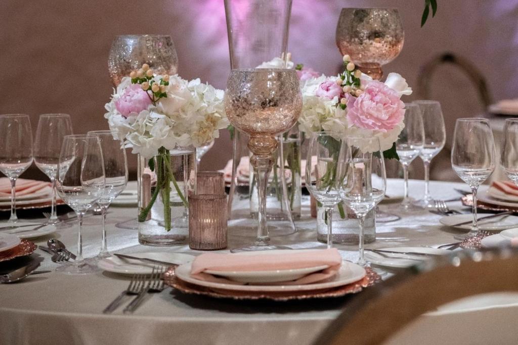a table with wine glasses and flowers on it at Aloft Dallas Downtown in Dallas