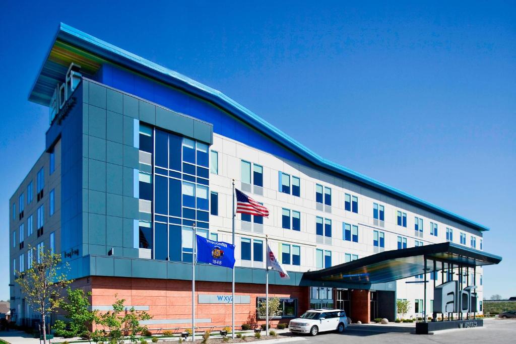 a building with a car parked in front of it at aloft Green Bay in Green Bay