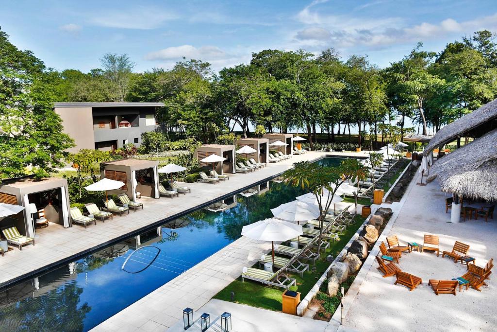 eine Aussicht über den Pool des Resorts mit Stühlen und Sonnenschirmen in der Unterkunft El Mangroove Papagayo, Autograph Collection in Culebra