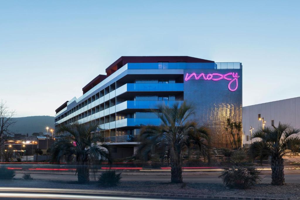 a large building with a purple sign on it at Moxy La Ciotat in La Ciotat