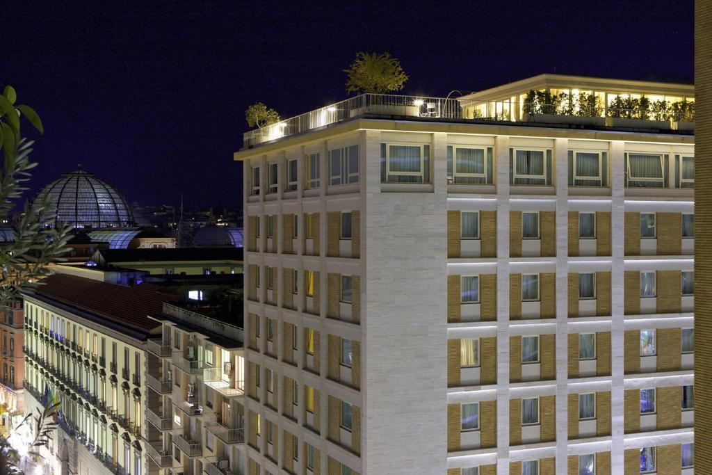 ナポリにあるルネッサンス ナポリ ホテル メディテッラネオの夜間の灯り付きの建物